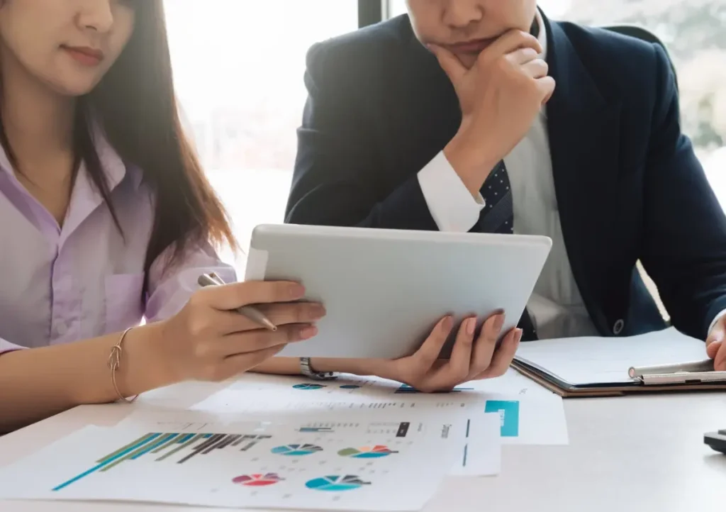 Two professionals reviewing data on an ipad.