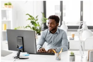 Man working at a computer in a bright office.