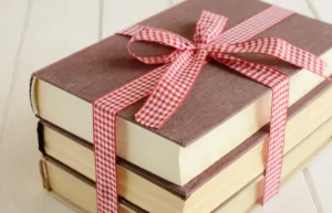 Stack of books tied with a red and white checkered ribbon.