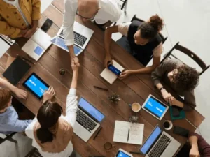 Group working together at a table with their laptops.