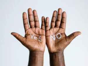 Hands held open with the words yes and no written on the palms.