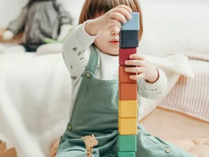 A child stacking colorful blocks.